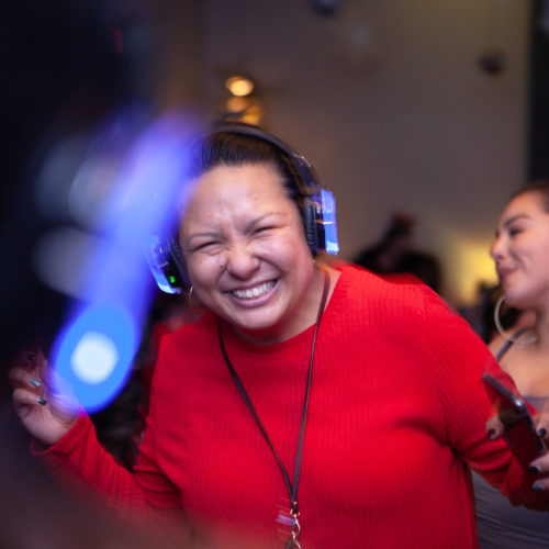 woman wearing headphones smiling at camera